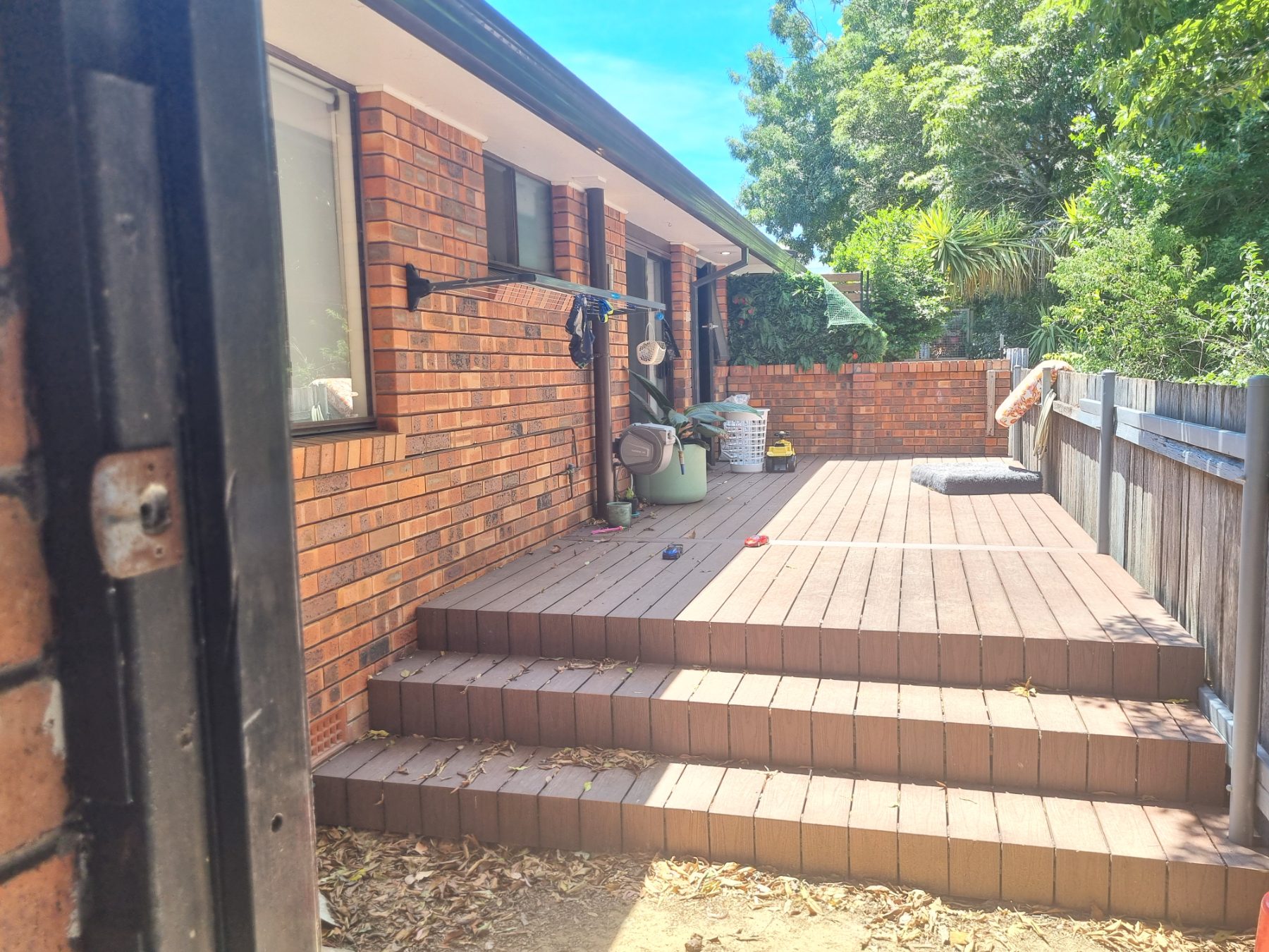 Timber-look composite deck and steps along a brick home
